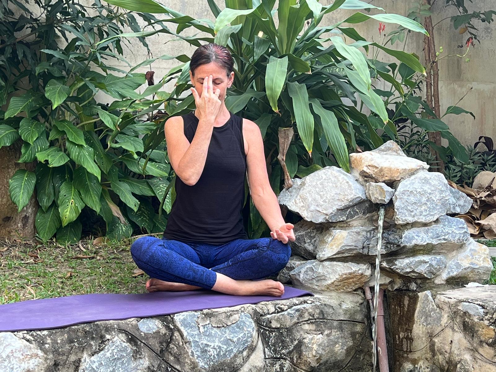 Photo of mentor practicing Nadi Shodhana pranayama during yoga teacher mentoring programme Luang Prabang